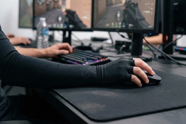 A gamer wearing a black thumb-hole gaming sleeve while using a mouse