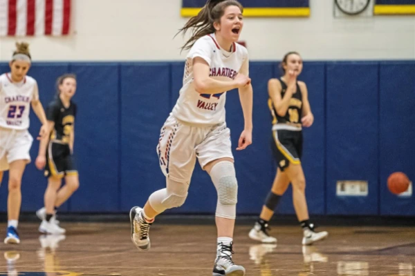 Female basketball player running down court wearing knee sleeves for squats to basketball