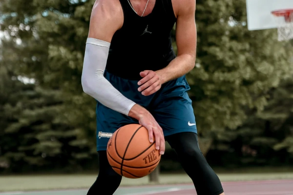 Basketball athlete wearing arm sleeves for performance, protection, and temperature control