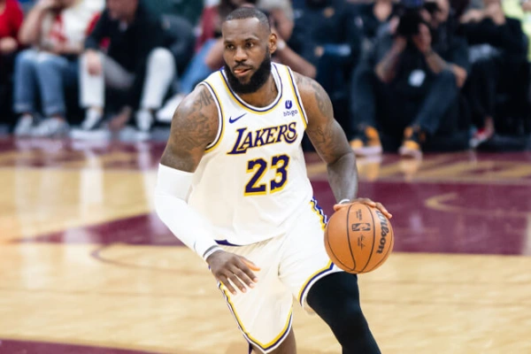 Basketball player wearing a compression arm sleeve while holding a basketball on court