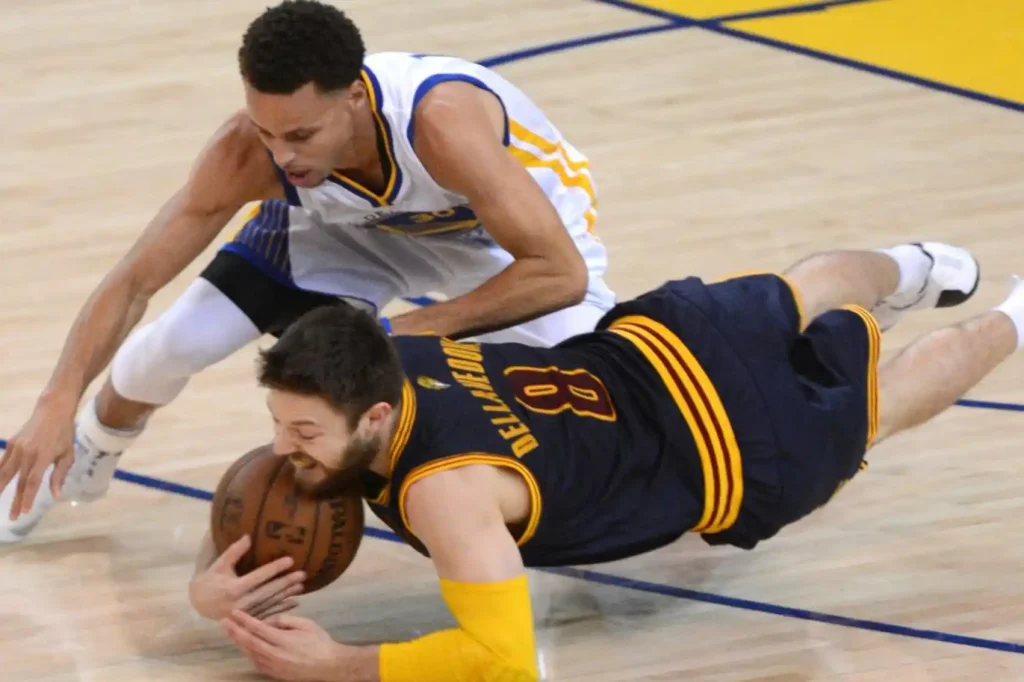 “Basketball player wearing an arm sleeve while diving for a loose ball for abrasion protection