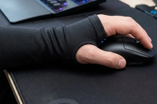Close-up of a gamer wearing a black thumb-hole sleeve holding a mouse