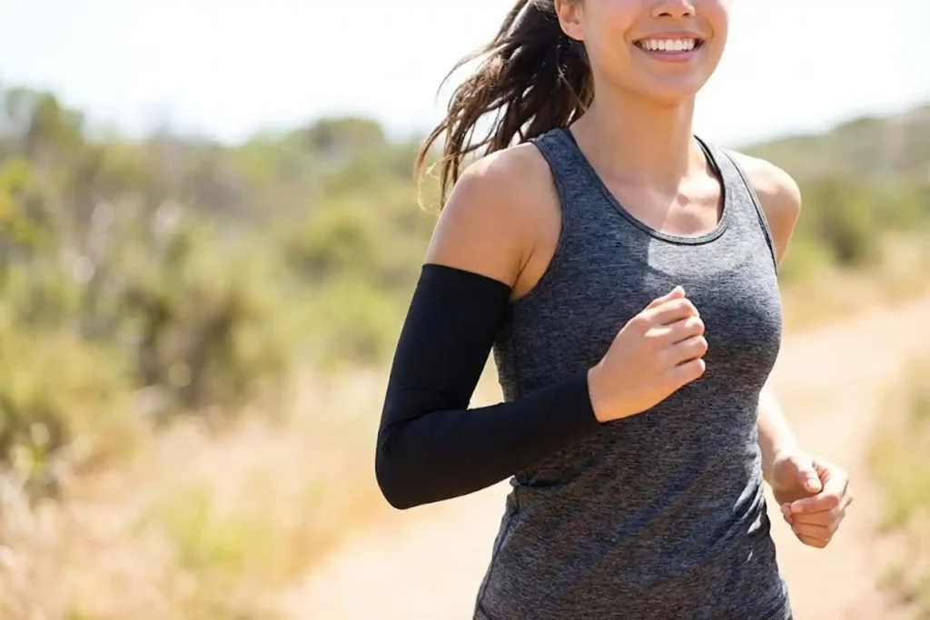 Happy female runner wearing a perfectly fitting black arm sleeve that stays in place during a run