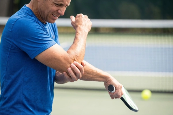 Injured elbow_ A pickleball player wincing in pain
