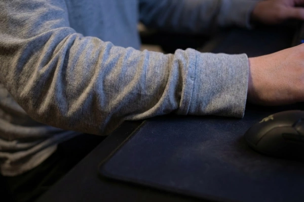 Loose long-sleeve shirt cuff and wrinkles creating friction drag on a gaming mousepad