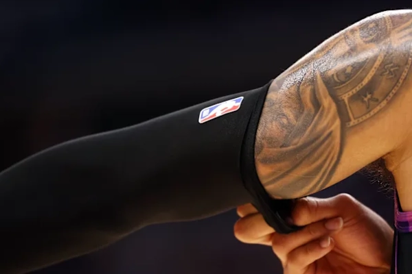 Putting on an arm sleeve by rolling it from the wrist and sliding it up the arm step by step