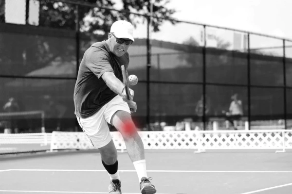 pickleball players wearing knee braces and wrist supports running on court dynamic action fast paced injury prevention